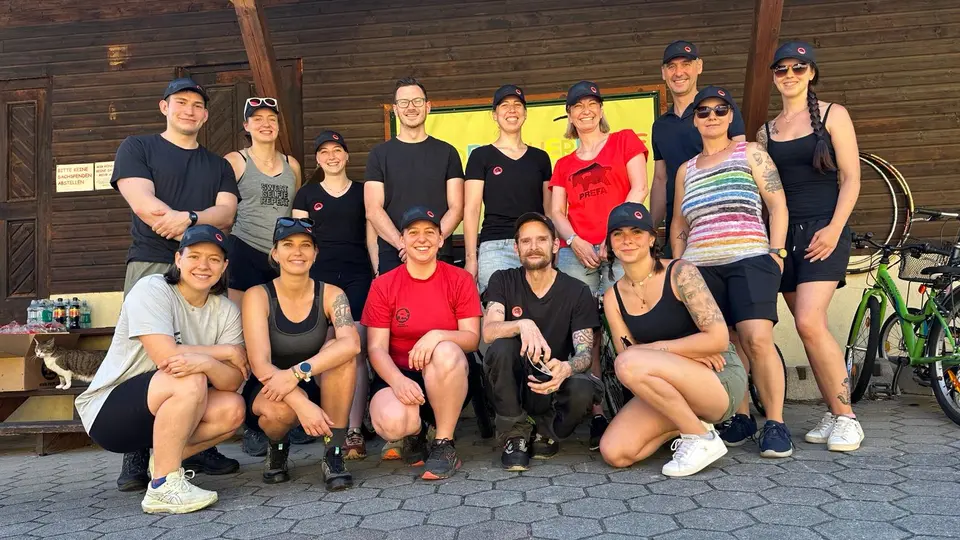 Gruppenfoto von PREFA Mitarbeitenden beim Social Team Tag am Kinderbauernhof Eschenau: Vor einer rustikalen Holzfassade versammelt und mit markanten roten PREFA-Shirts und -Caps als Eyecatcher zeigt das Team tatkräftiges CSR-Engagement. Die Szene vermittelt Dynamik, Zusammenhalt und nachhaltige Verantwortung. PREFA unterstreicht damit auch bei sozialen Projekten im regionalen Umfeld den eigenen Anspruch an Qualität und Beständigkeit.