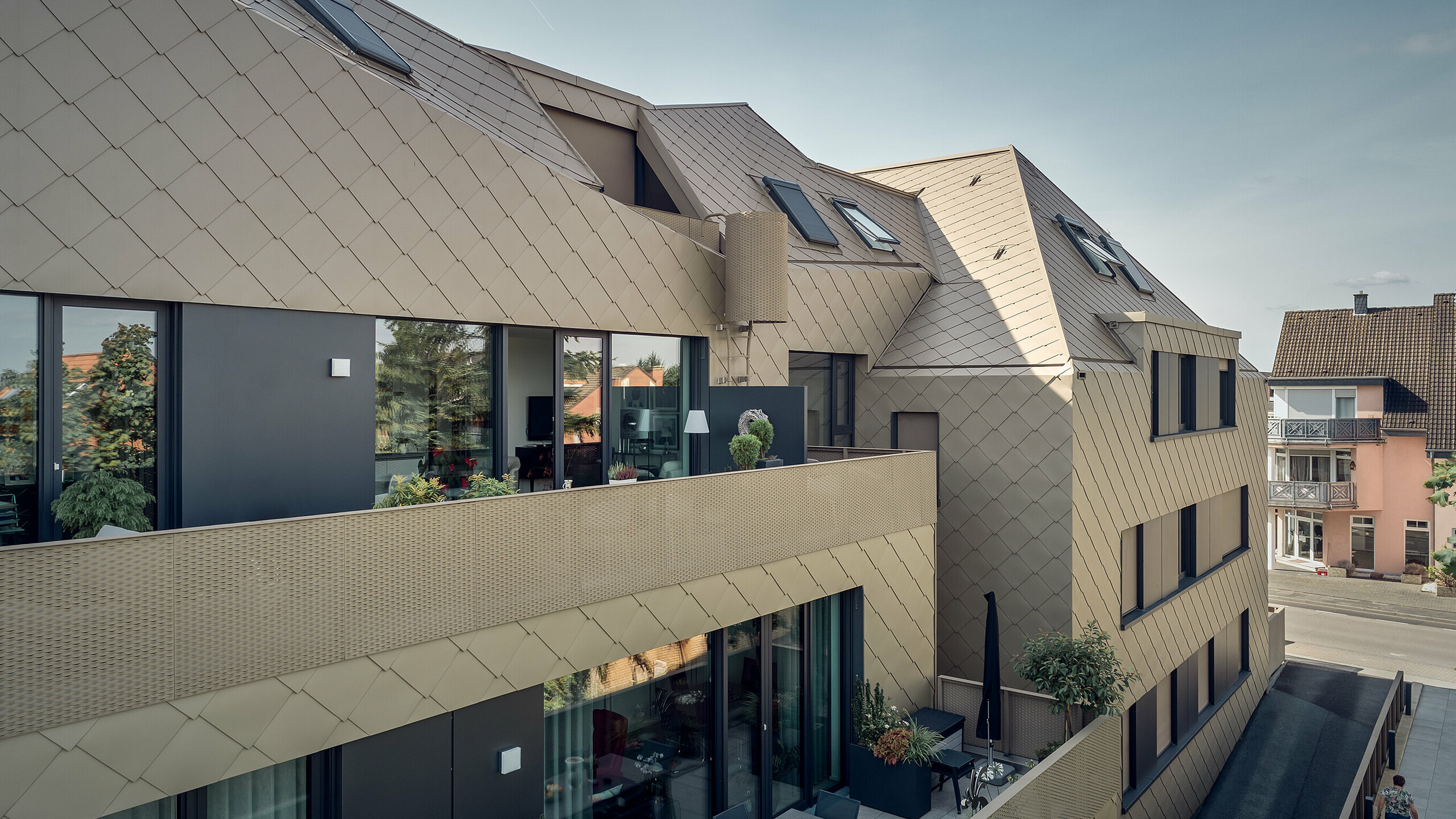 Eine Seitenansicht zeigt die kristalline Dachform und das rautenförmige Design der PREFA Lösungen.