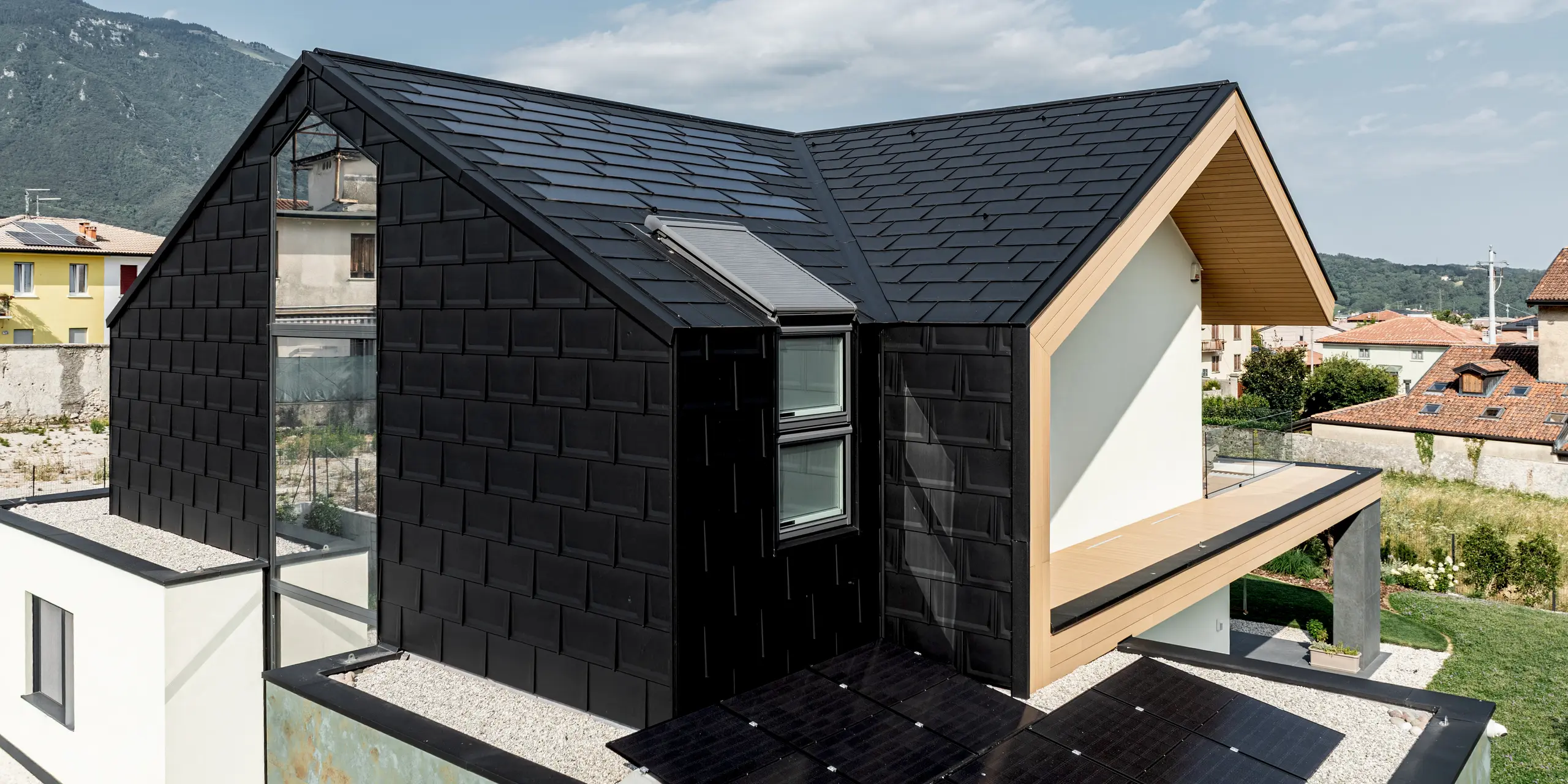 Außergewöhnliches Einfamilienhaus in Vicenza mit PREFA Dachplatten R.16 an Dach und Fassade in P.10 Schwarz. Die präzise Aluminiumverkleidung betont die klare Architektur und schafft ein elegantes, monochromes Erscheinungsbild. Dank hoher Widerstandsfähigkeit und Langlebigkeit bietet PREFA zuverlässigen Schutz und eine hochwertige Gestaltungslösung für anspruchsvolle Gebäude.