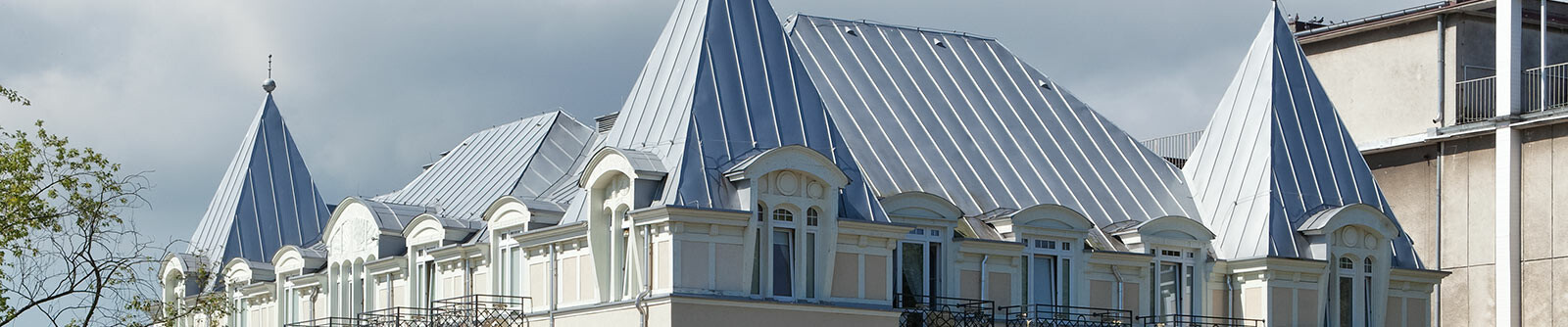 Neu eingedecktes Dach des Hotel Burstzyn mit einem silberfarbenen Bandblech von PREFA