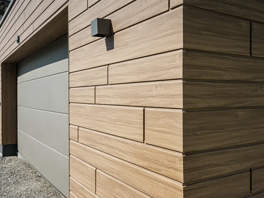 Nahaufnahme einer mit PREFA Sidings in Holzoptik verkleideten Garage. Als Farbe wurde Walnussbraun gewählt.