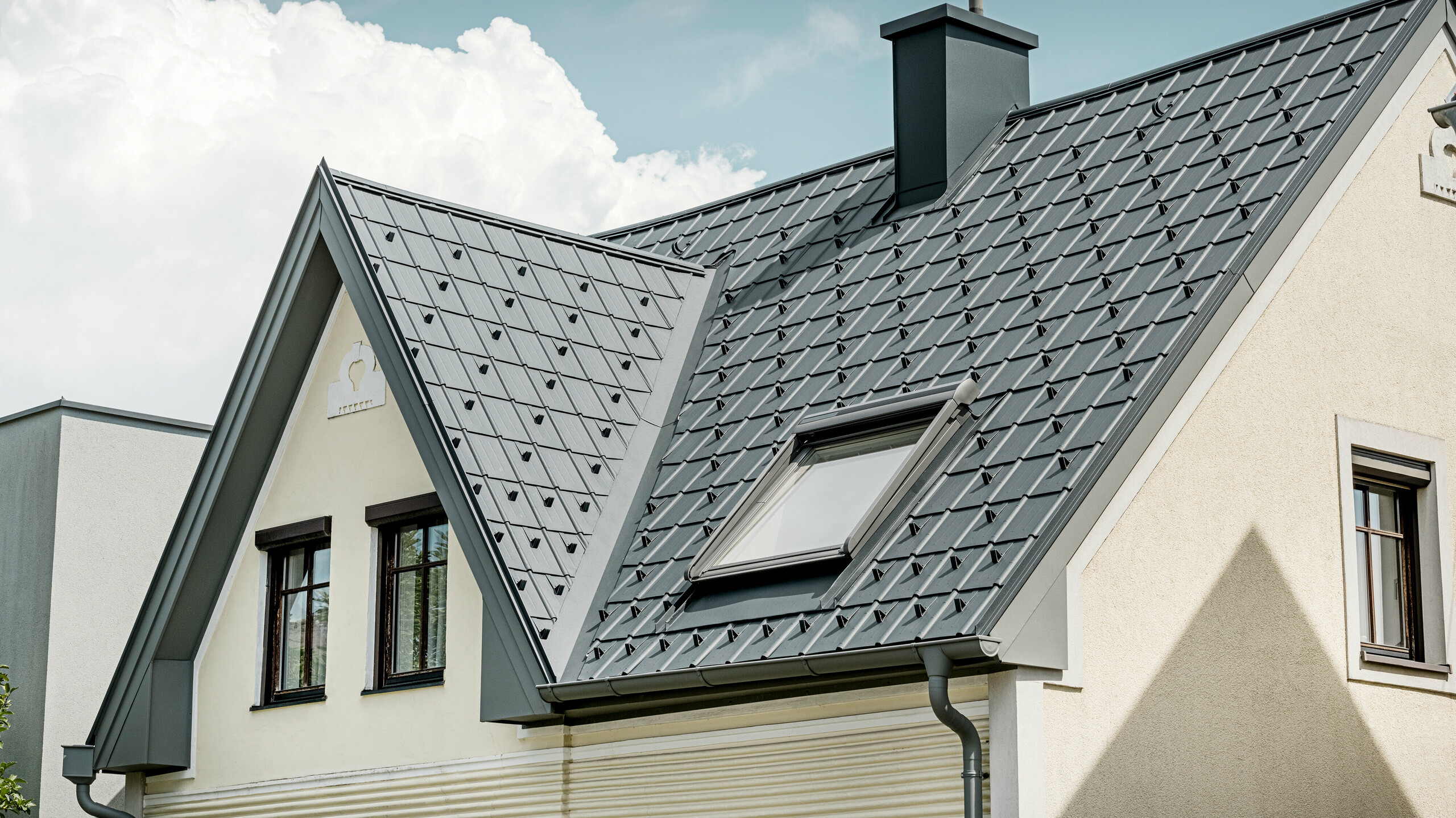 Einfamilienhaus in St. Valentin mit PREFA Dachplatte in anthrazit und einem Dachentwässerungssystem von PREFA in hellgrau