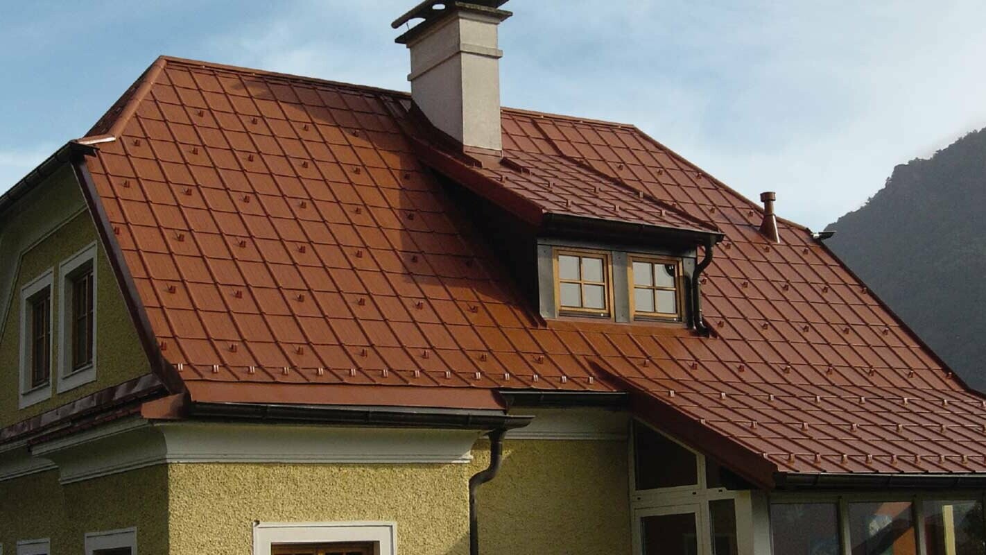Einfamilienhaus mit Krüppelwalmdach und Gaube mit neu saniertem Dach mit der PREFA Dachplatte in Ziegelrot