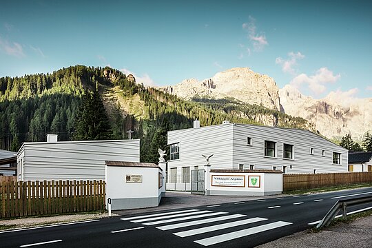 Vor einer eindrucksvollen Bergkulisse verbinden die vier Neubauten des Logistik- und Übungszentrums „Villaggio Alpino Tempesti” alpine Landschaft mit moderner Architektur. Die präzise verlegten PREFALZ-Aluminiumscharen in der Farbe P.10 Prefaweiß sorgen für eine klare Linienführung, eine hohe Widerstandskraft und klimatische Vorteile. Sie sind ein funktionales Designstatement im Herzen Südtirols. Vor der Zufahrtsstraße zu der modernen Kaserne befindet sich eine Straße mit Zebrastreifen.