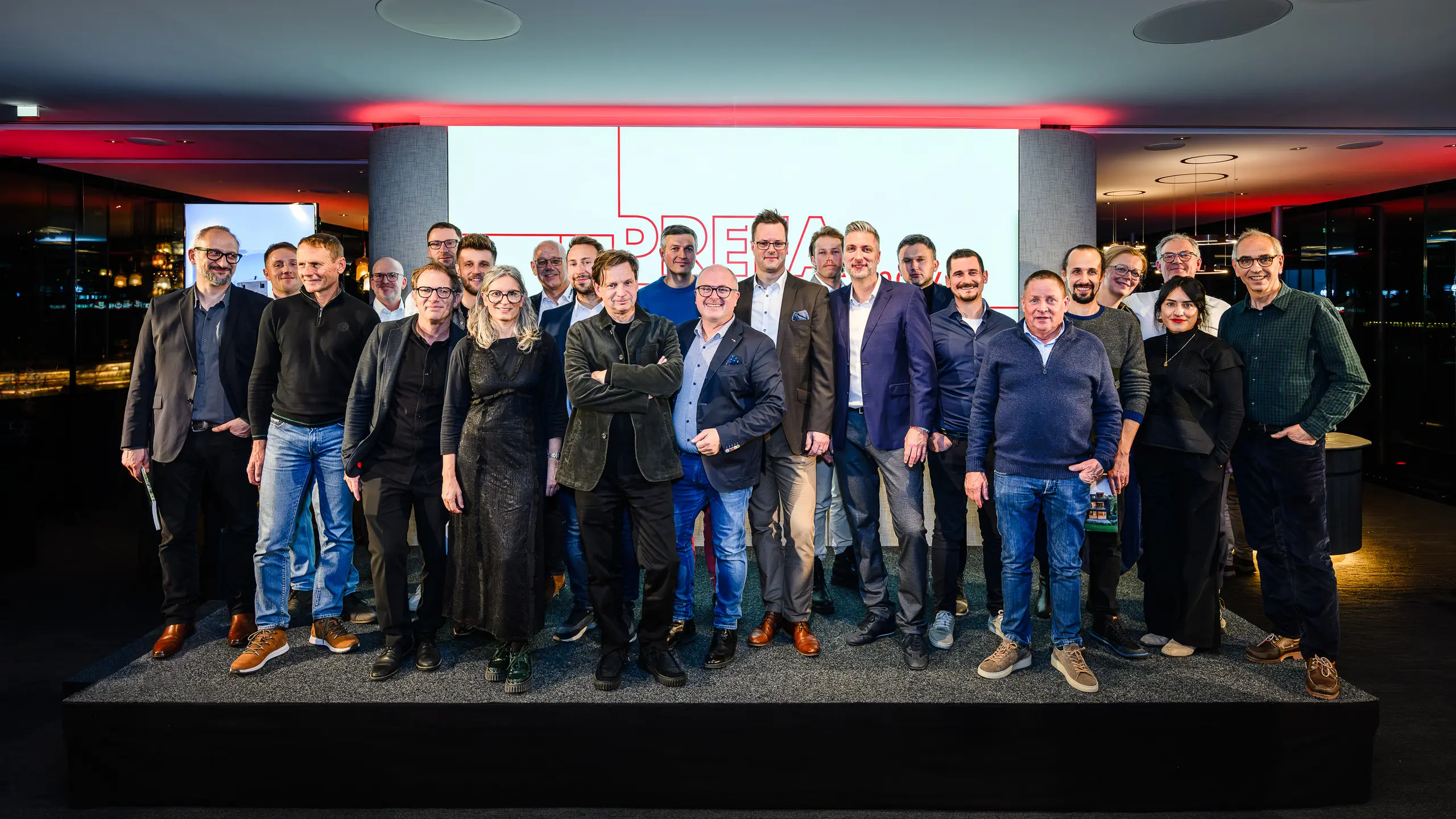 Gruppenfoto der Architekt:innen, Planer:innen und Verarbeiter:innen auf der Bühne der PREFARENZEN Präsentation 2026 im k47.wien – ein starkes Symbol für Gemeinschaft, Kreativität und zukunftsweisende Architektur. Vor dem leuchtenden PREFARENZEN-Logo stehen die Gestalter:innen hinter den beeindruckenden Projekten mit PREFA Aluminium. Die Szene spiegelt Stolz, Innovation und Zusammenarbeit wider. PREFA Produkte bieten langlebige, witterungsbeständige Lösungen mit ästhetischem Anspruch – ideal für moderne Architekturkonzepte. Ein inspirierender Abend voller Austausch, Visionen und starken Partnerschaften.