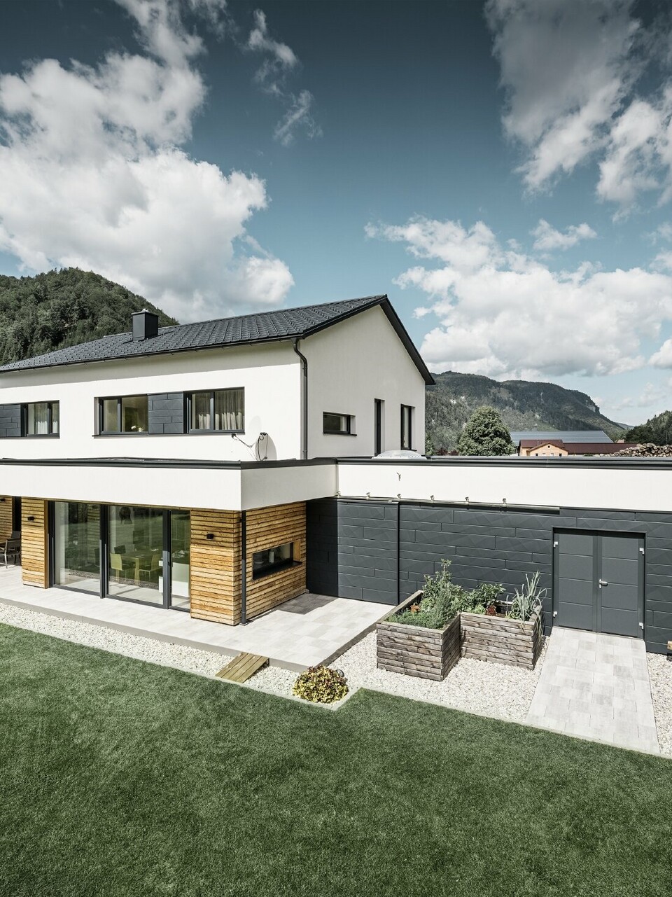 Modernes Einfamilienhaus in ländlicher Umgebung mit PREFA Dach- und Fassadenprodukten. 