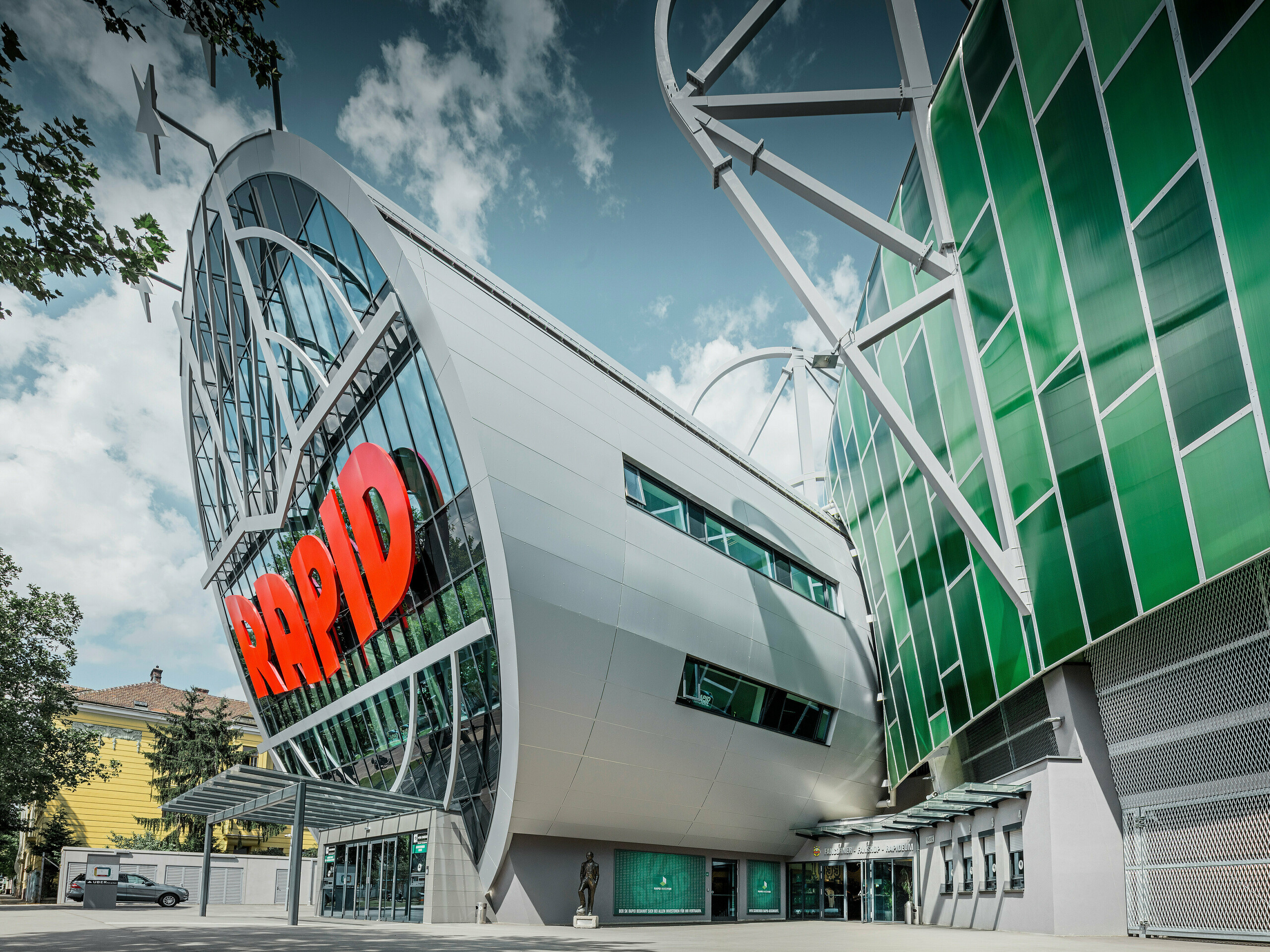 Das Allianz Stadion des SK Rapid Wien, gekennzeichnet durch eine imposante Röhre im Eingangsbereich. Die Röhre misst einen Durchmesser von 20 Meter. Die spektakuläre Fassade der Röhre ist mit PREFA Aluminium Verbundplatten in Silbermetallic verkleidet. Die Aluminiumhülle verleiht der Struktur ein futuristisches Design, das Technologie und Sportgeist in harmonischer Architektur vereint.