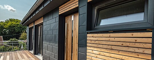 Die speziell gekanteten PREFA Siding.X kombiniert mit einer klassischen Holzfassade