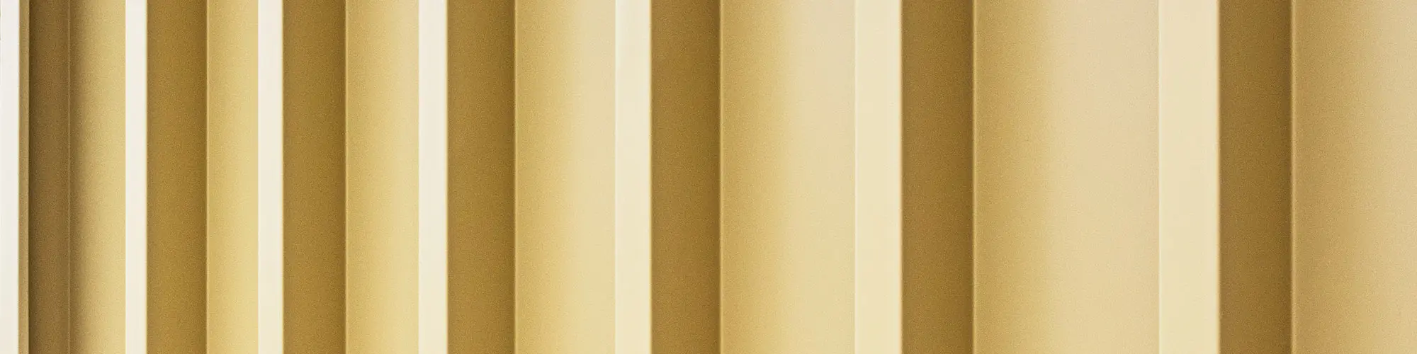 Ein Detail der linierten, savannenbeigen Prefalz Fassade, die eine besondere Strahlkraft besitzt.