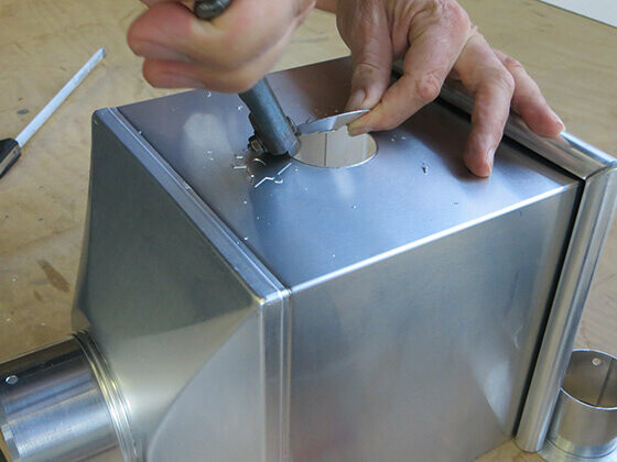 Schritt 3 beim Anfertigen eines Notüberlaufs bei einem PREFA Wasserfankasten - Loch an der Markierung ausschneiden
