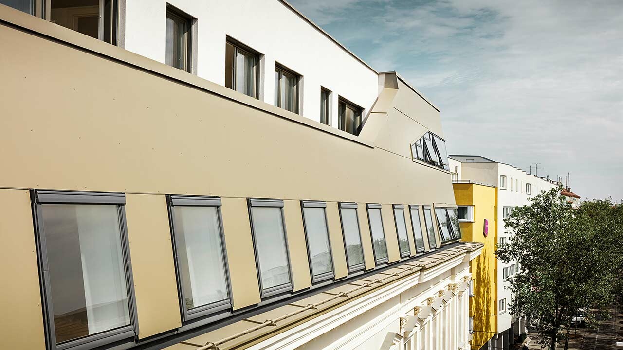 Moderner Dachausbau eines Gründerzeithauses in der Schloßhofer Straße in Wien, eingekleidet mit der Aluminium Verbundplatte in Bronze