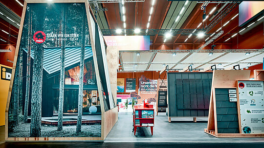 PREFA Messestand 2026 mit kraftvoller Markeninszenierung: Das Motto „Stark wie ein Stier“ prägt den ersten Eindruck und unterstreicht die robuste Qualität der PREFA Produkte für Dach, Fassade und Solar. Eine großformatige Fassadenabbildung mit moderner Architektur und Aluminiumdach zeigt anschaulich die gestalterische Vielfalt des Systems. Rechts im Bild: Solarlösungen, Dachsysteme und ein Infoboard zu Nachhaltigkeit und Umweltschutz. Der Stand überzeugt durch klare Struktur, hochwertige Präsentation und starke visuelle Botschaften – ein Blickfang für Bauherren, Planer und Verarbeiter, die langlebige, klimafitte Lösungen suchen. PREFA setzt neue Maßstäbe in Design, Funktion und Energieeffizienz.