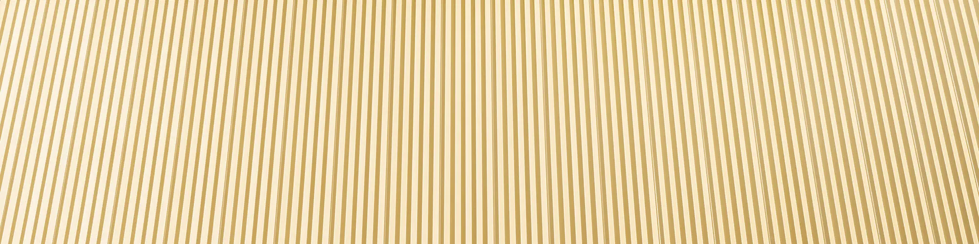 Ein Ausschnitt des Zackenprofils der mayagoldenen Fassade aus nächster Nähe.