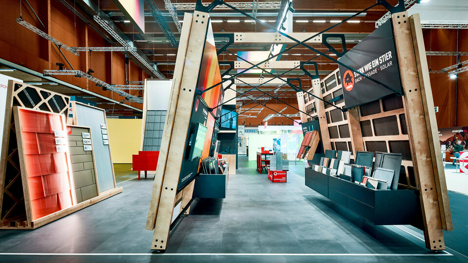 Beeindruckender PREFA Messestand mit innovativer Architektur und klarer Produktinszenierung: In Szene gesetzt werden moderne Dach- und Fassadensysteme aus langlebigem Aluminium sowie integrierte Solarlösungen. Eyecatcher wie die spezielle Beleuchtung und multimediale Infopoints zeigen die Vielfalt und Systemlogik des PREFA Komplettangebots. Die imposante Konstruktion aus Holz und Stahl vermittelt Stabilität und Designbewusstsein – ganz im Sinne des Mottos „Stark wie ein Stier“. Der offene, strukturierte Aufbau lädt Besucher dazu ein, Produkte hautnah zu erleben, technische Details zu verstehen und Inspiration für Sanierung und Neubau zu sammeln.