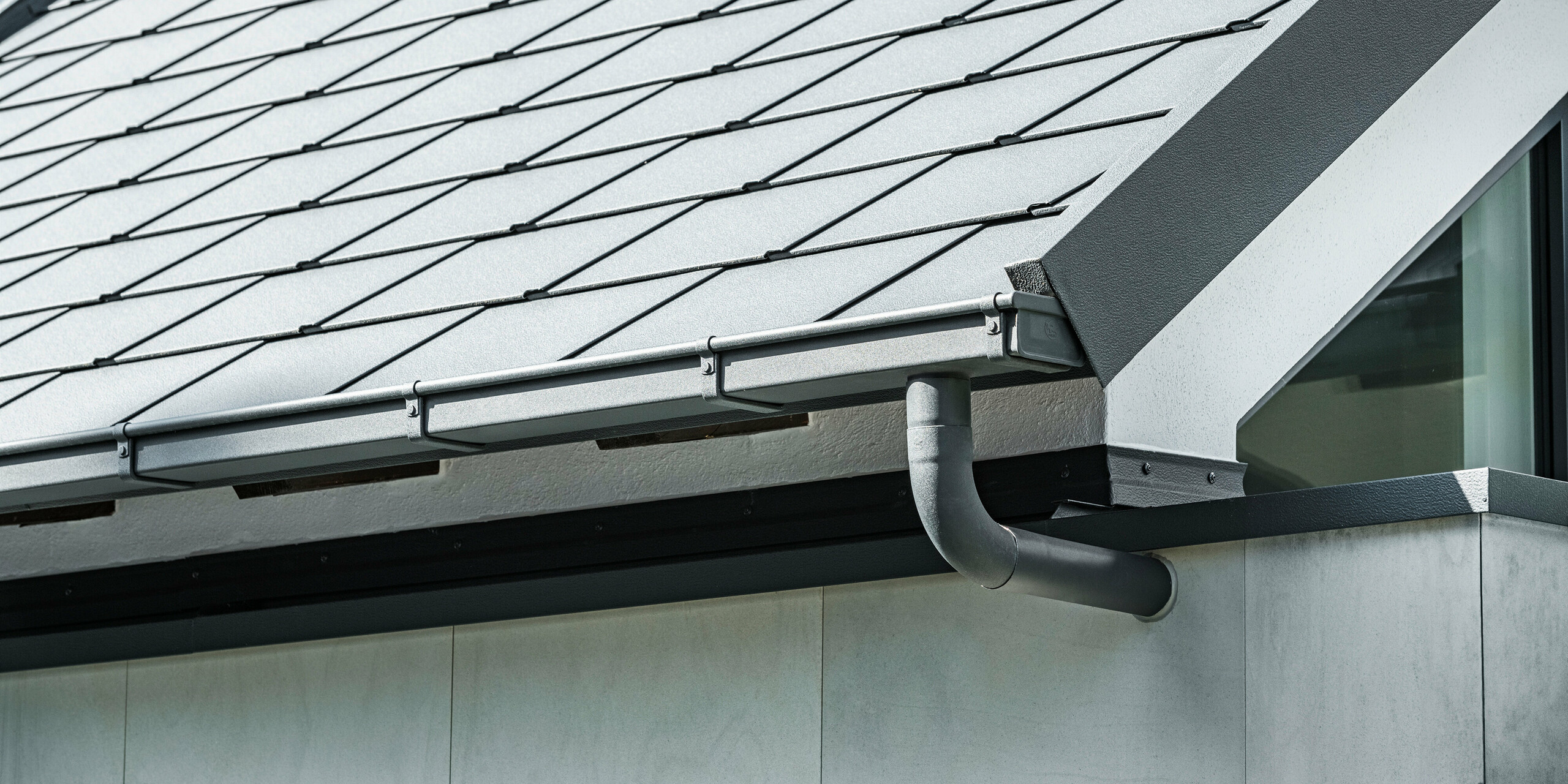 PREFA Dachentwässerungssystem und Dachschindeln DS.19 in P.10 Anthrazit am Dach eines Einfamilienhauses in Dortmund.