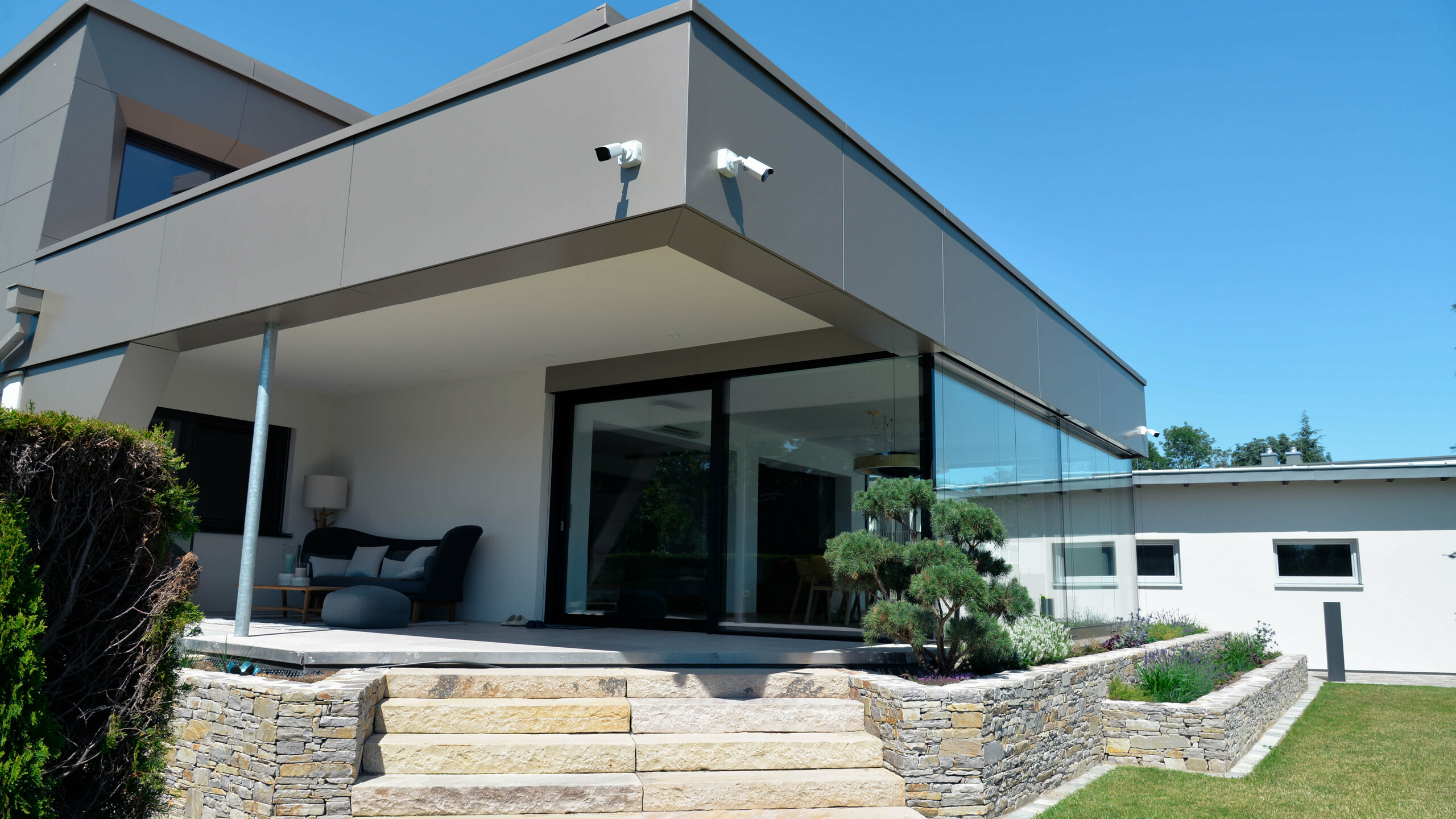 Schräger Blick auf den Stiegenaufgang zur Terrasse, die mit PREFA Aluminium Verbundplatten in Bronze umhüllt ist