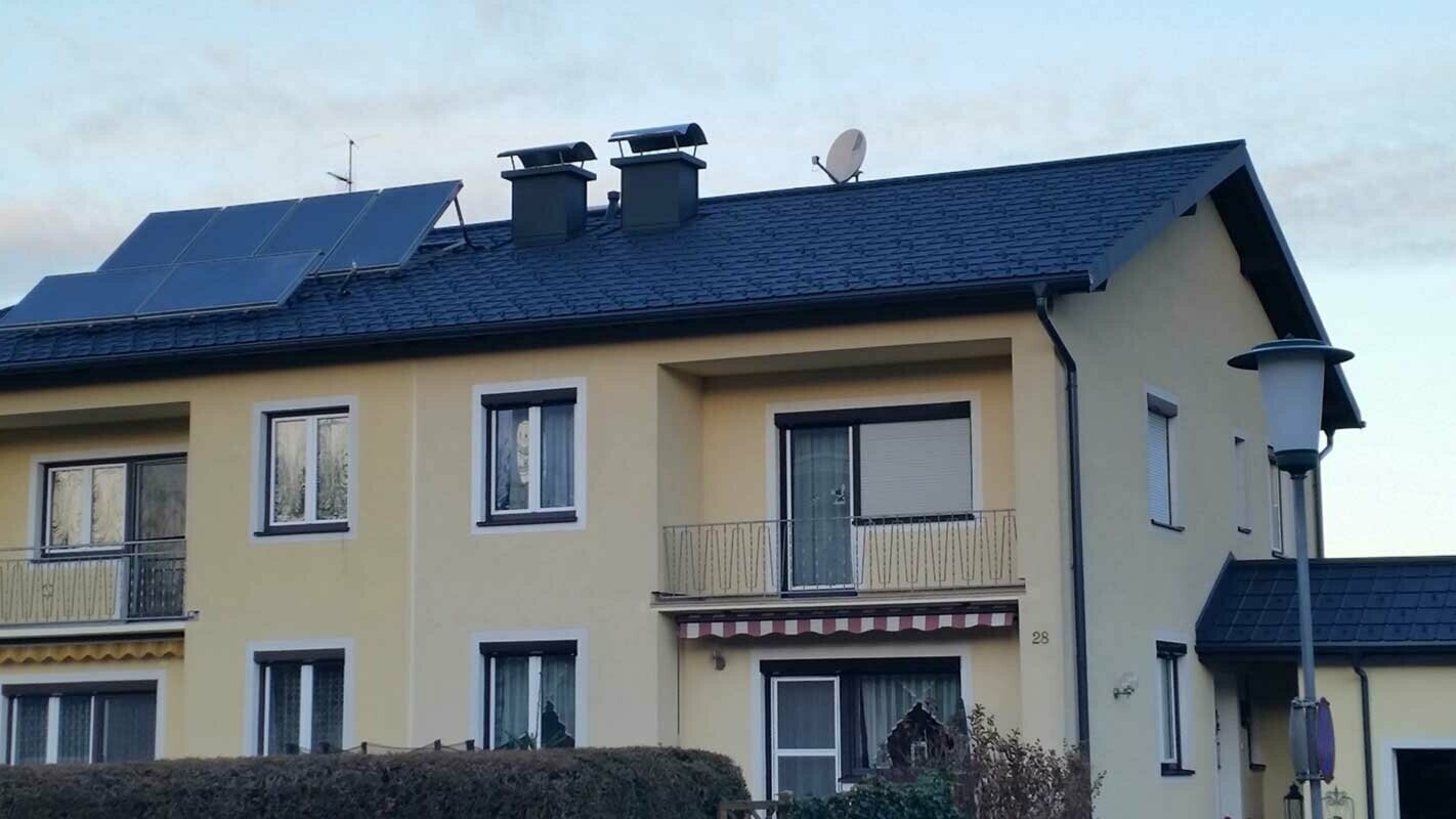 Mehrparteienhaus nach der Dachsanierung mit der PREFA Dachplatte in Österreich