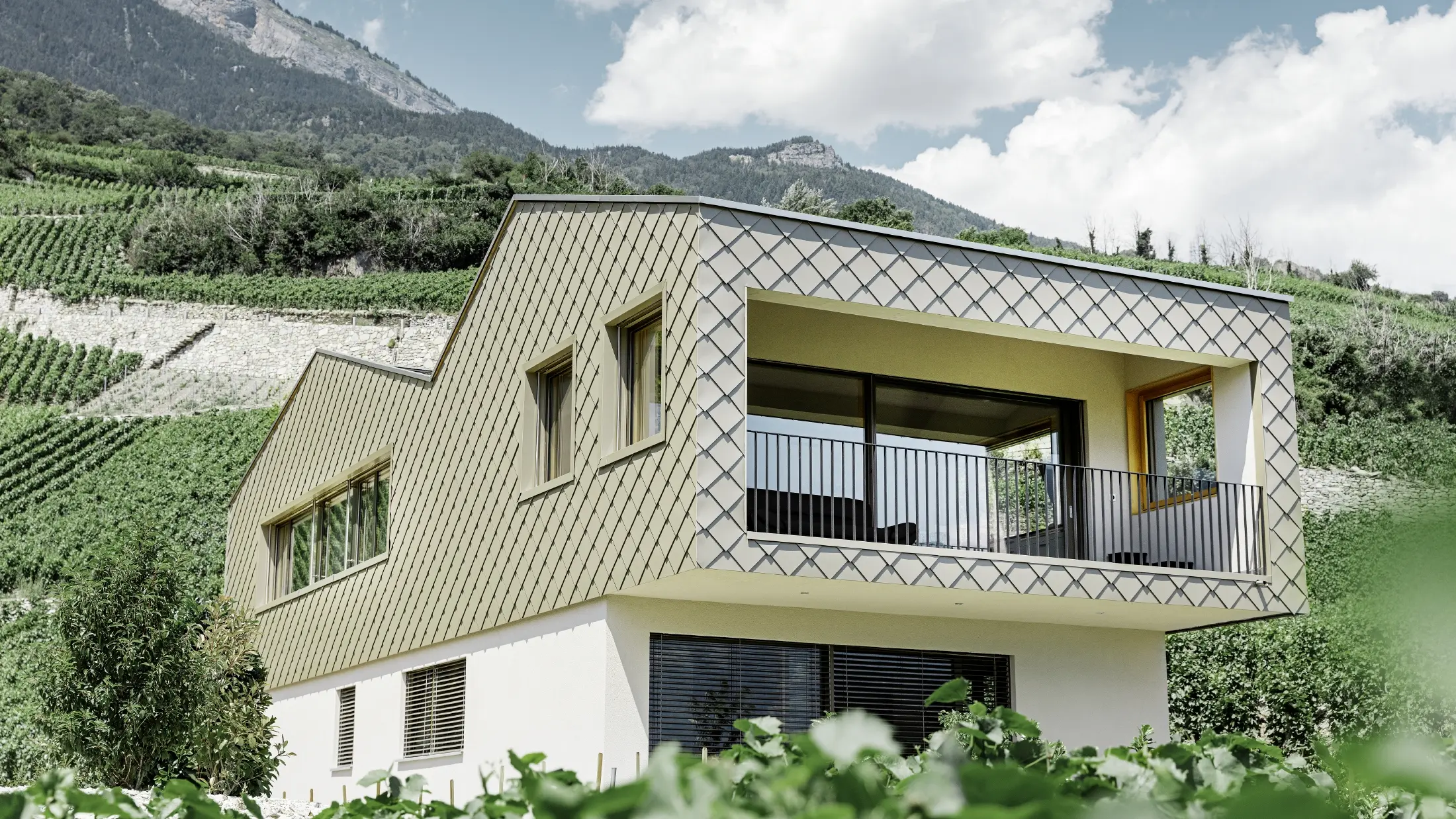 modernes Einfamilienhaus mitten in den Weinbergen des Rhônetals mit 4 unterschiedlichen Dachflächen und offener Galerie mit einer Rautenfassade in bronze