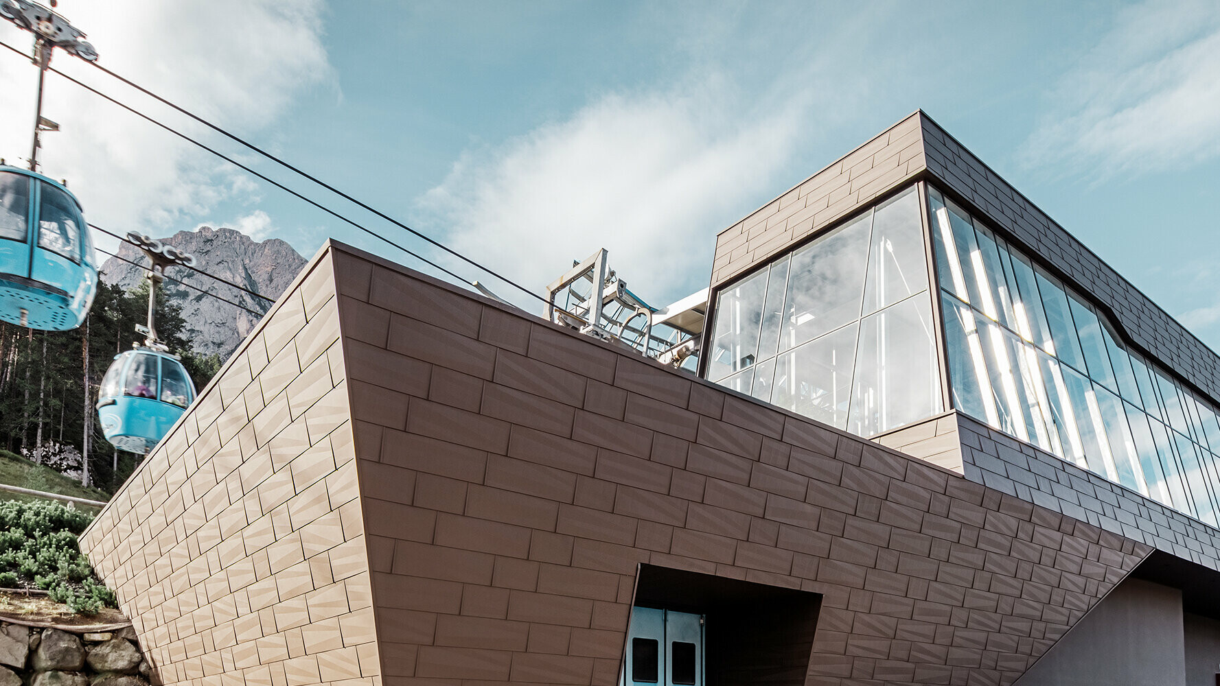 Talstation einer Umlaufbahn in Südtirol mit moderner Dach- und Fassadenverkleidung von PREFA in der Farbe Braun.