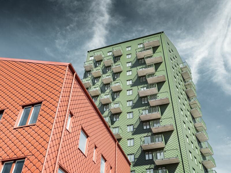 Ansicht von unten auf die neuen Wohnhäuser in Göteburg, die Fassade wurde eingedeckt mit PREFA Rauten in Erdfarben 