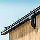 Untersicht eines Dachvorsprungs mit der PREFA Kastenrinne in Anthrazit mit Rinnenkessel an einer Holzfassade.