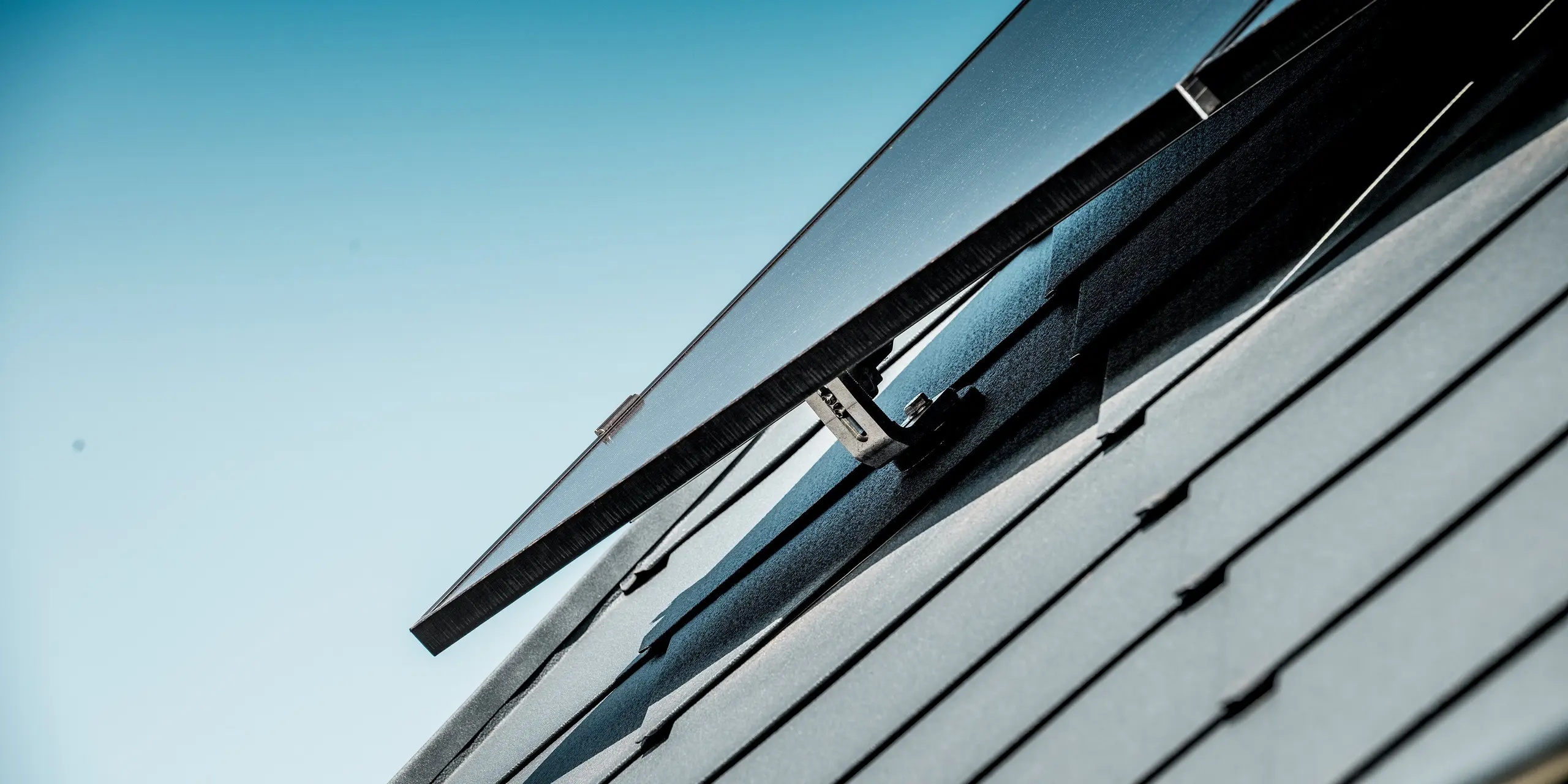 Detailaufnahme der Photovoltaik-Anlage auf dem sanierten Einfamilienhaus in Hargesheim. Das PREFA Solarmontagesystem ermöglicht eine sichere Befestigung der Photovoltaikmodule auf der PREFA Dachraute 44 × 44 in P.10 Anthrazit. Die präzise abgestimmte Montage fügt sich harmonisch in die strukturierte Dachfläche ein und verbindet nachhaltige Energiegewinnung mit langlebigem, witterungsbeständigem Aluminium.