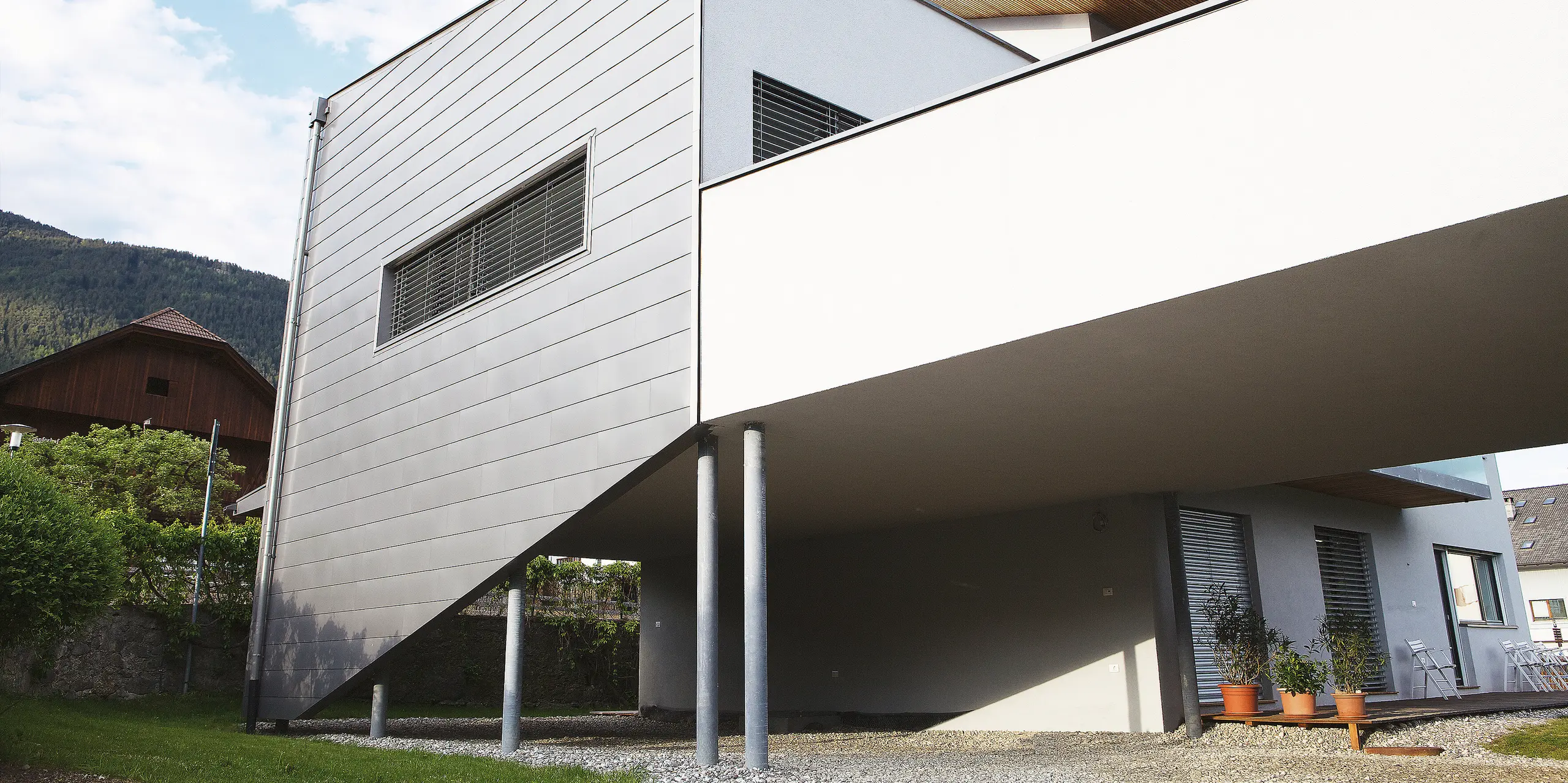 Die Rückansicht des Hauses in Pfalzen zeigt die durchgehende PREFALZ Fassadenbekleidung. Die langlebige PREFA Oberfläche trotzt Wind und Wetter und bleibt wartungsarm - ideal für anspruchsvolle Bauherren, die Wert auf Qualität und Design legen.