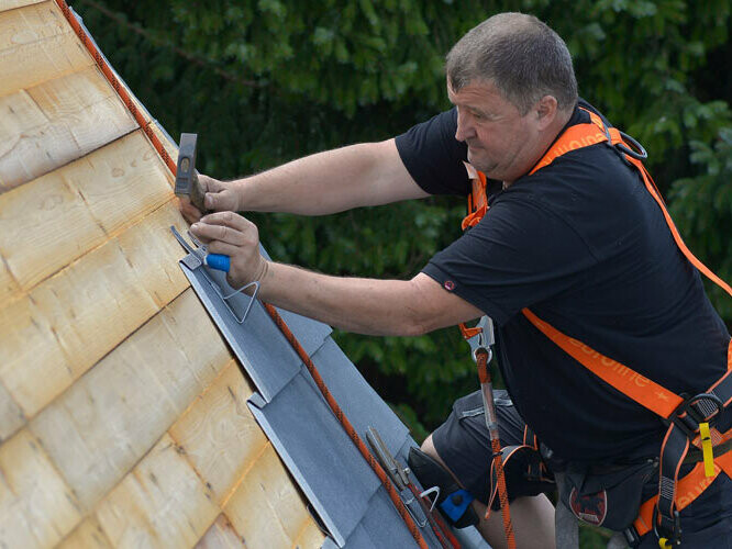 Handwerker deckt PREFA Dacheindeckung aus Aluminium 