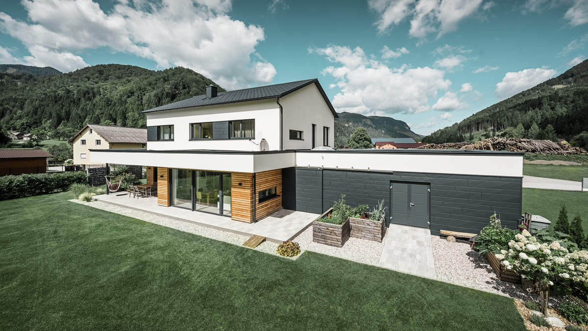 Einfamilienhaus mit PREFA Siding.X in P.10 anthrazit für die Garage sowie zwischen den Fenstern und die PREFA Dachplatte in P.10 anthrazit für das Dach.