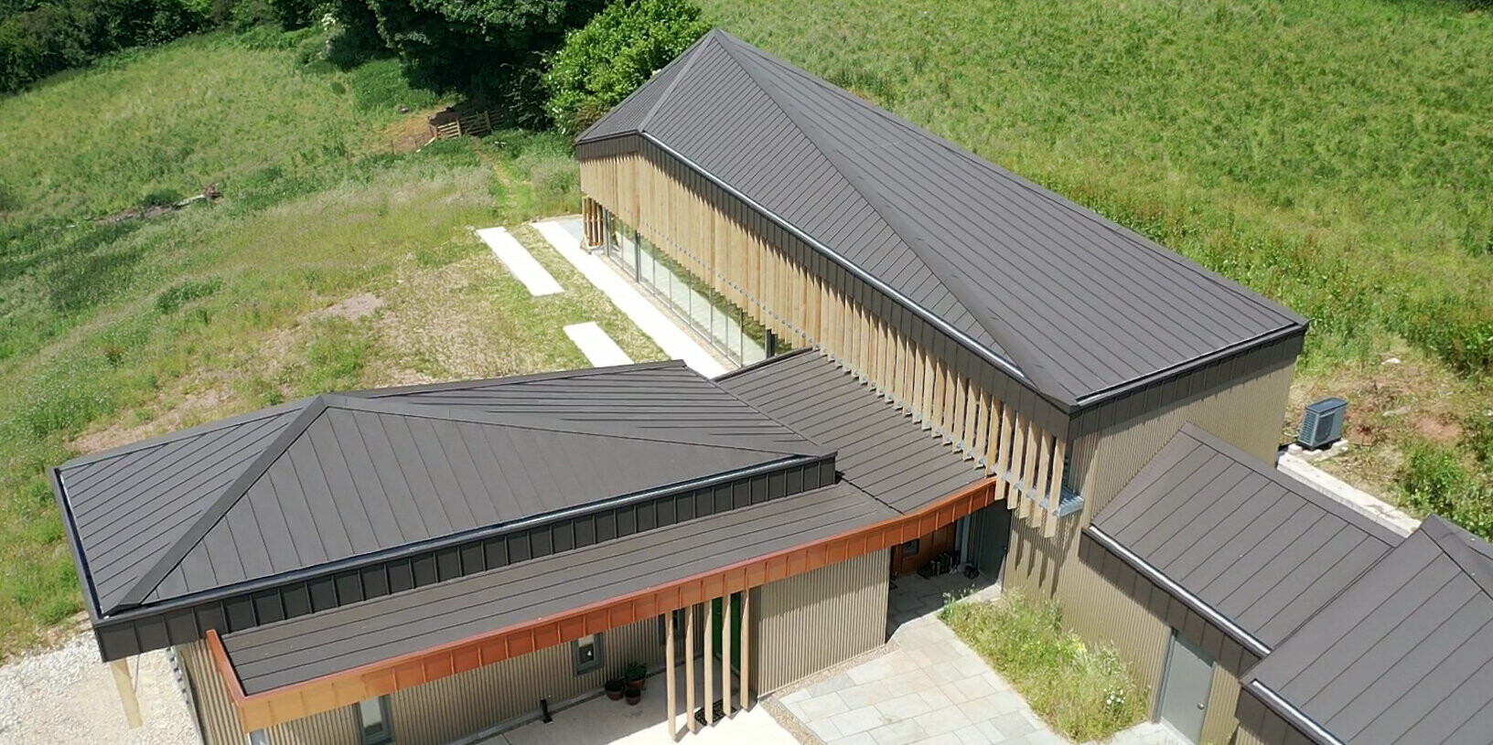 Vogelperspektive auf den Eingang zu einem Langhaus in Derbyshire mit einem PREFA Aluminiumdach in Braun
