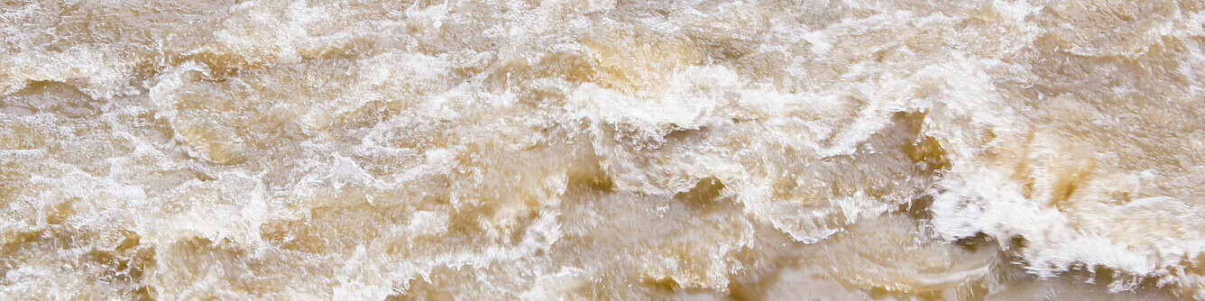 Fluss mit Hochwasser, Überschwemmung bei Unwetter
