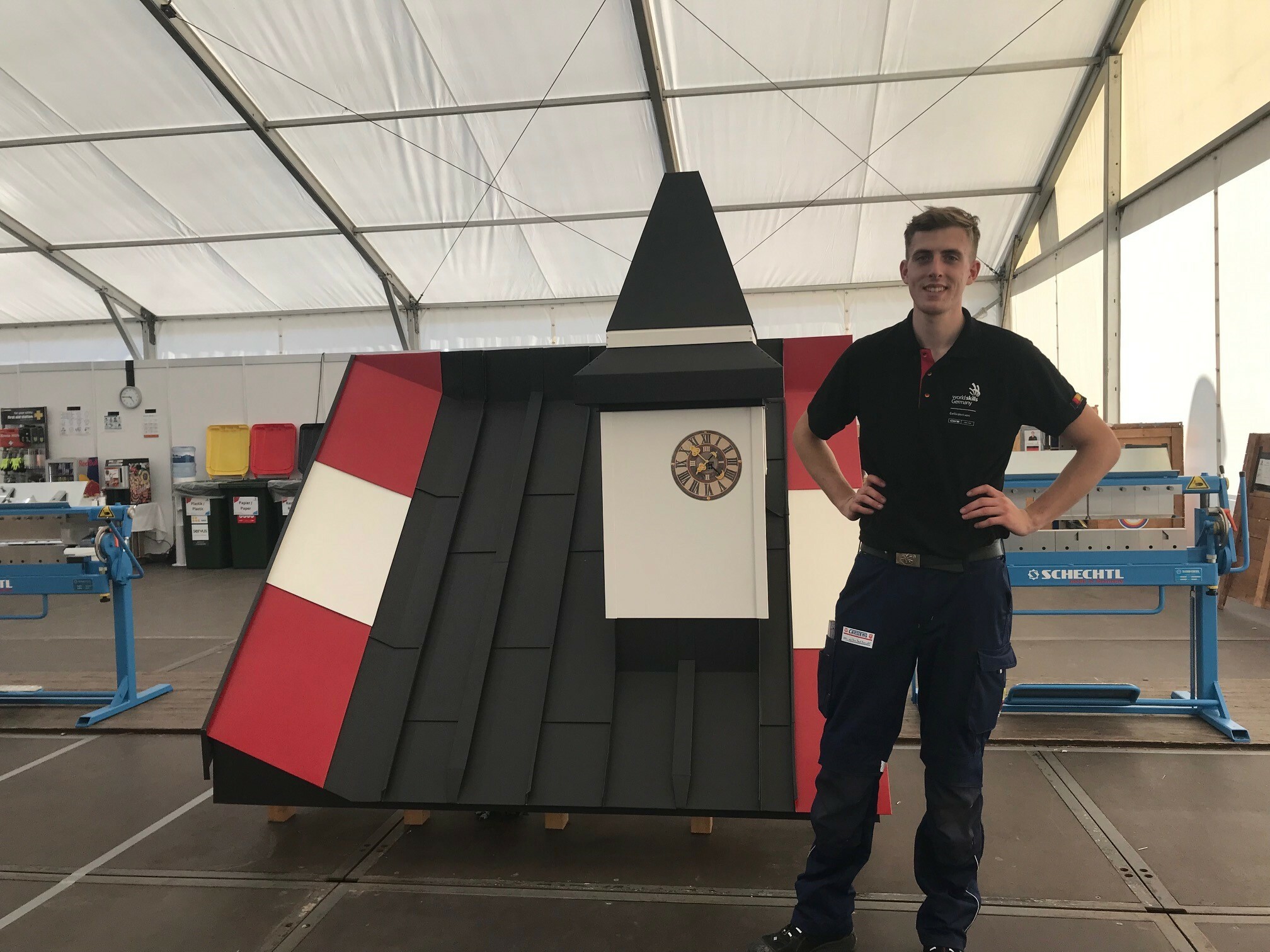 Jonas Carstens - Teilnehmer aus Deutschland - stemmt die Arme in die Hüfte und lächelt vor dem fertigen Wettbewerbsmodell