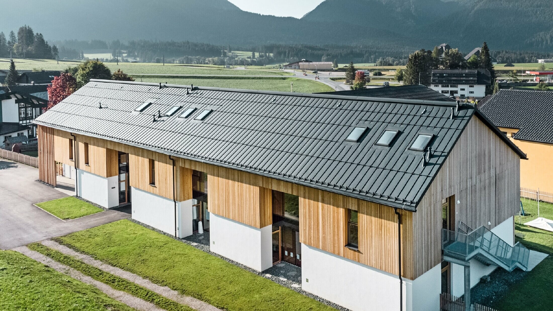 Kräuterkindergarten in Bad Mitterndorf mit großem PREFALZ Dach in P.10 Anthrazit und Holzfassade