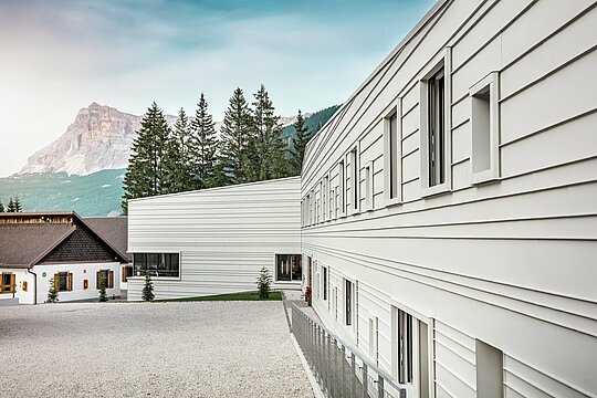 Klares Licht, scharfe Linien: Die Fassade der Kaserne „Tempesti“ in Südtirol zeigt eindrucksvoll, wie sich modernes Design in die Berglandschaft einfügt. Die horizontalen PREFALZ-Scharen in der Farbe P.10 Prefaweiß reflektieren das Sonnenlicht, verbessern das Mikroklima und überzeugen durch ihre robuste, langlebige Qualität. Sie sind ein starkes Beispiel für durchdachte Militärarchitektur mit Aluminium.