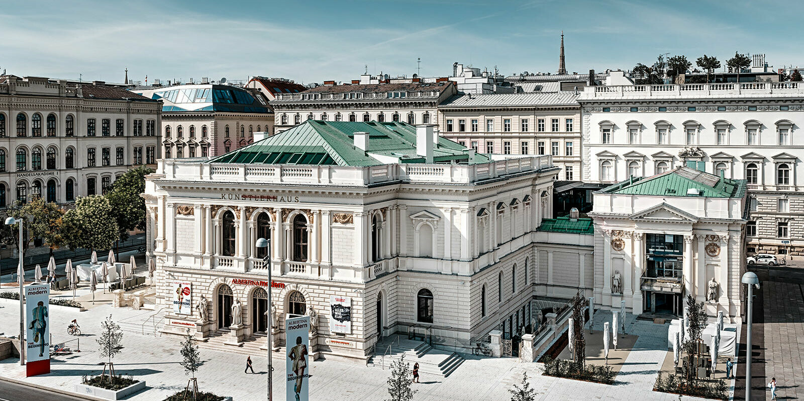 Es ist das Künstlerhaus in Wien zu sehen, umgeben von anderen Gebäuden.