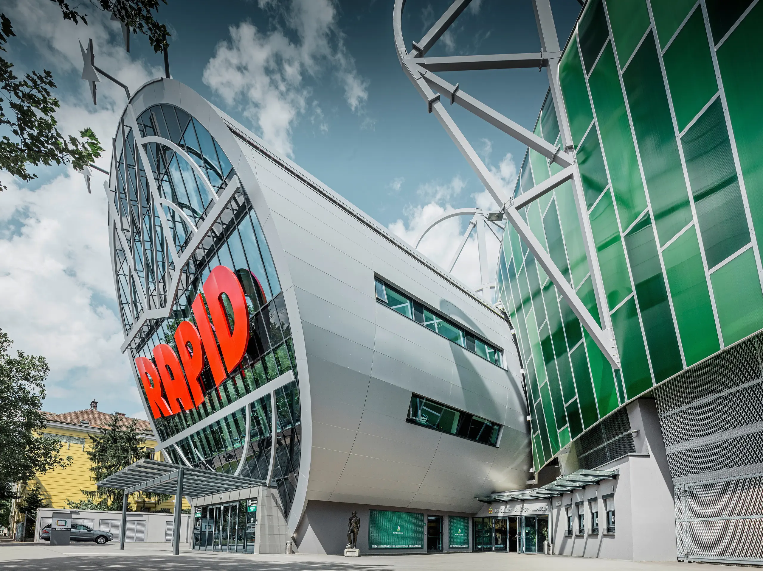 Das Allianz Stadion des SK Rapid Wien, gekennzeichnet durch eine imposante Röhre im Eingangsbereich. Die Röhre misst einen Durchmesser von 20 Meter. Die spektakuläre Fassade der Röhre ist mit PREFA Aluminium Verbundplatten in Silbermetallic verkleidet. Die Aluminiumhülle verleiht der Struktur ein futuristisches Design, das Technologie und Sportgeist in harmonischer Architektur vereint.