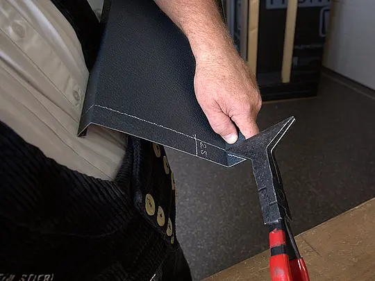 PREFA-Techniker Tom Weiß kantet die Aluminium-Platte entlang der vorher gezogenen Risse mithilfe einer Quetschfaltenzange nach hinten. 