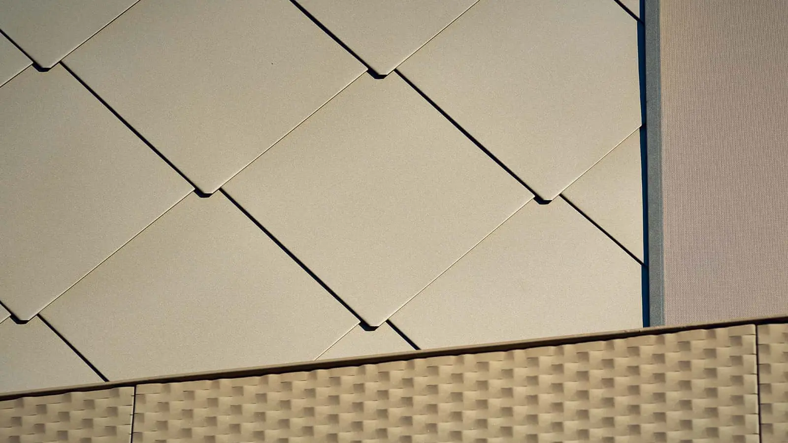 Das Bild zeigt eine Nahaufnahme der PREFA-Fassadenplatten 44 x 44 mit der Spezialbeschichtung P.10 Bronze.