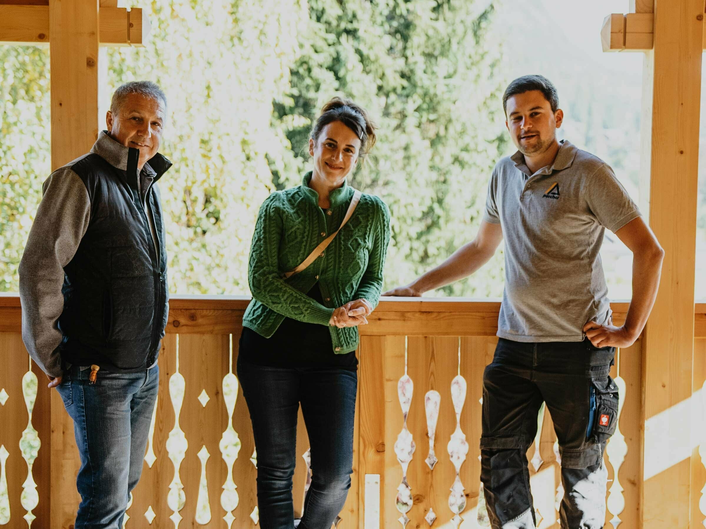 Aufnahme eines PREFA Mitarbeiters, der Architektin und des Dachdeckermeisters auf einem der Balkone des "Haus Hackerfeld"