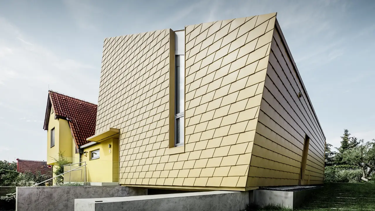 Sehr moderner Zubau eines Einfamilienhauses mit der Alu-Fassade von PREFA; verbaut wurden die PREFA Schindeln in Sandbraun;