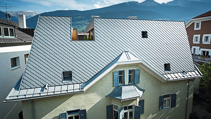 Aufstockung eines Gebäudes in Schlanders, das Gesamte Dachgeschoß wurde zu einer Loft-Wohnung umgebaut. Das Dach wurde mit der PREFA Dachraute eingedeckt.