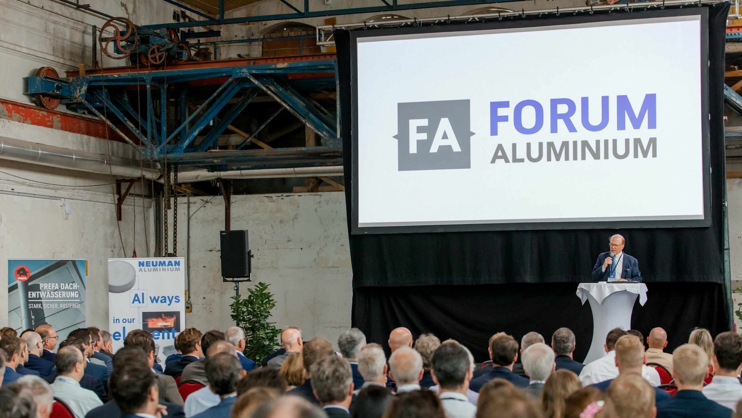 Bild einer Präsentation, auf der Leinwand ist "Forum Aluminium" abgebildet.