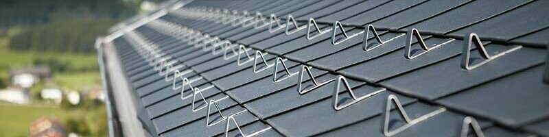 Detailaufnahme der PREFA Dachschindel in Anthrazit mit den PREFA Schneestoppern für den fachgerechten Schneeschutz