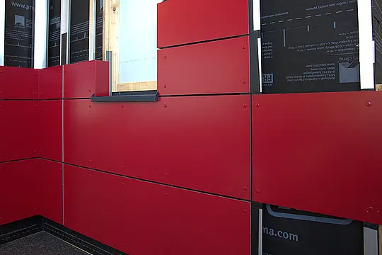 Bild einer PREFABOND Verbundplatte im Kreuzverband vor einer Holz-Unterkonstruktion.