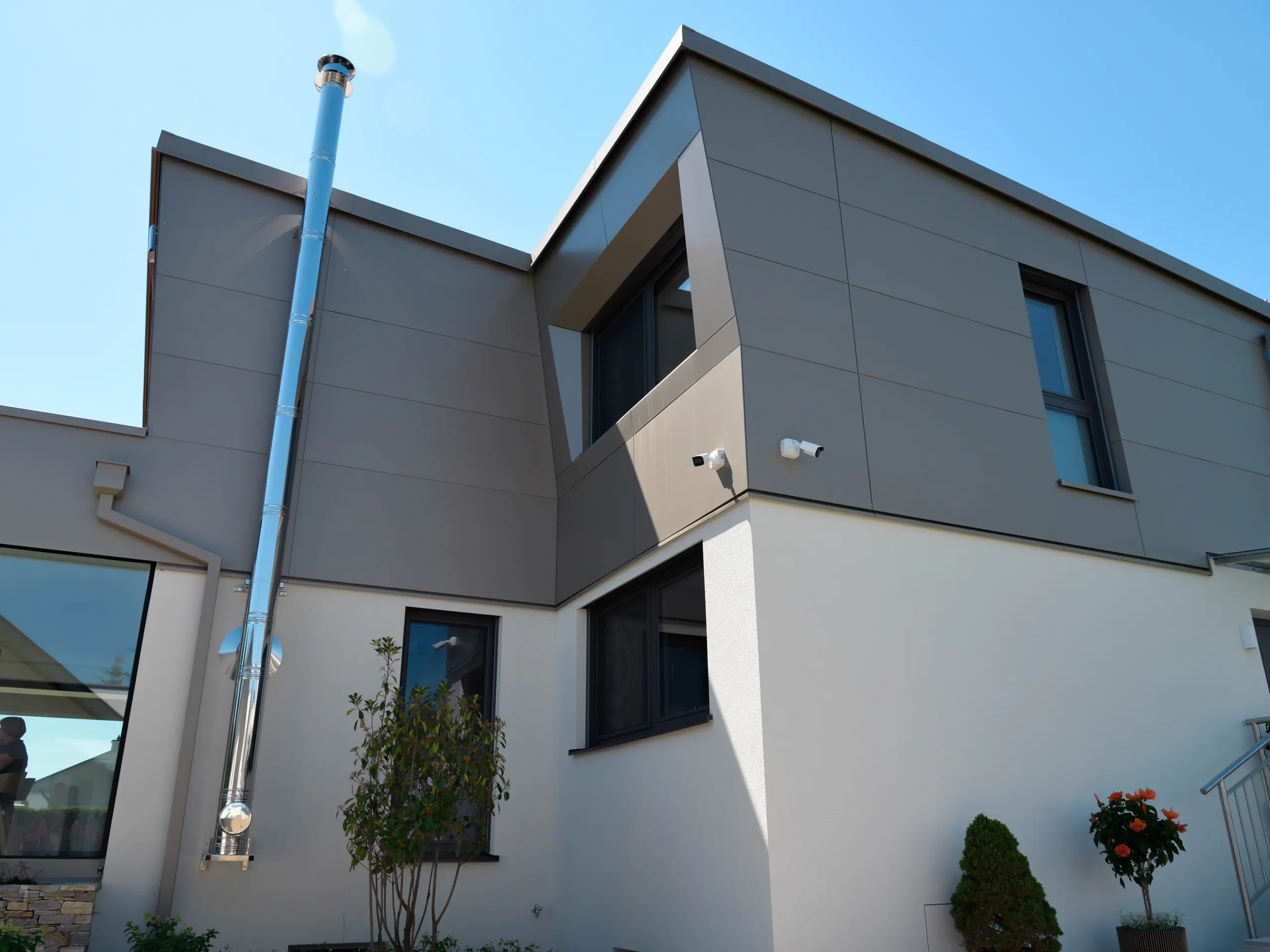 Eingang zum Einfamilienhaus in Viehofen, das großflächig mit PREFA Aluminium Verbundplatten an der Fassade und PREFALZ am Dach verkleidet wurde