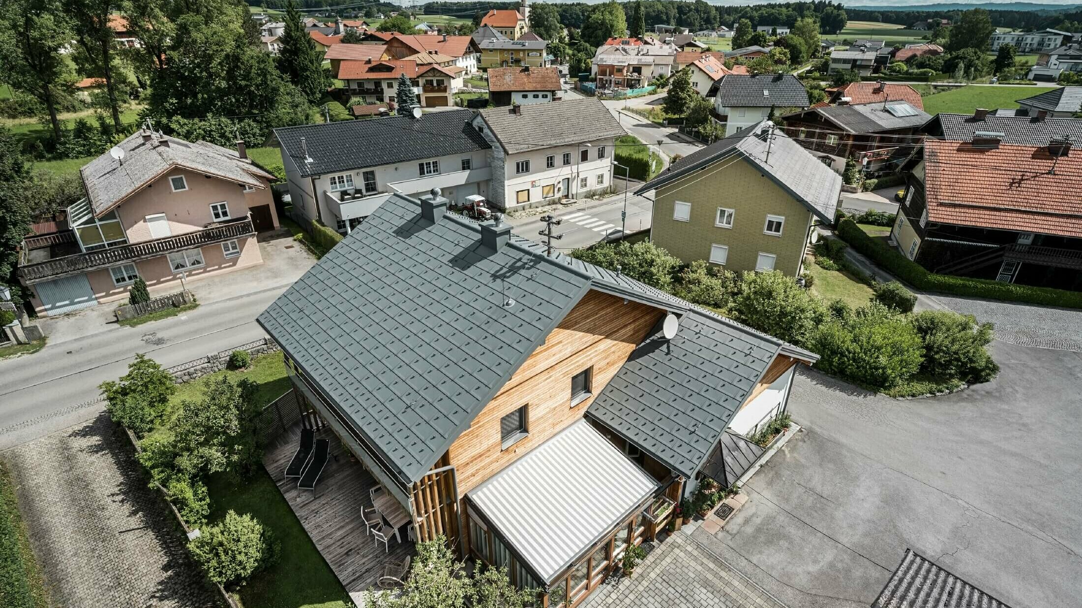 Ländliches Einfamilienhaus mit Holzfassade und hellgrauem PREFA Dach