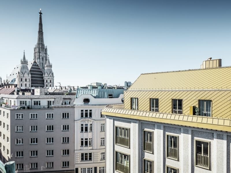 Dachgeschossausbau Wien Brandstätte mit PREFA Rauten in Perlgold; Aussicht vom Dachgeschoss auf den Stephansdom