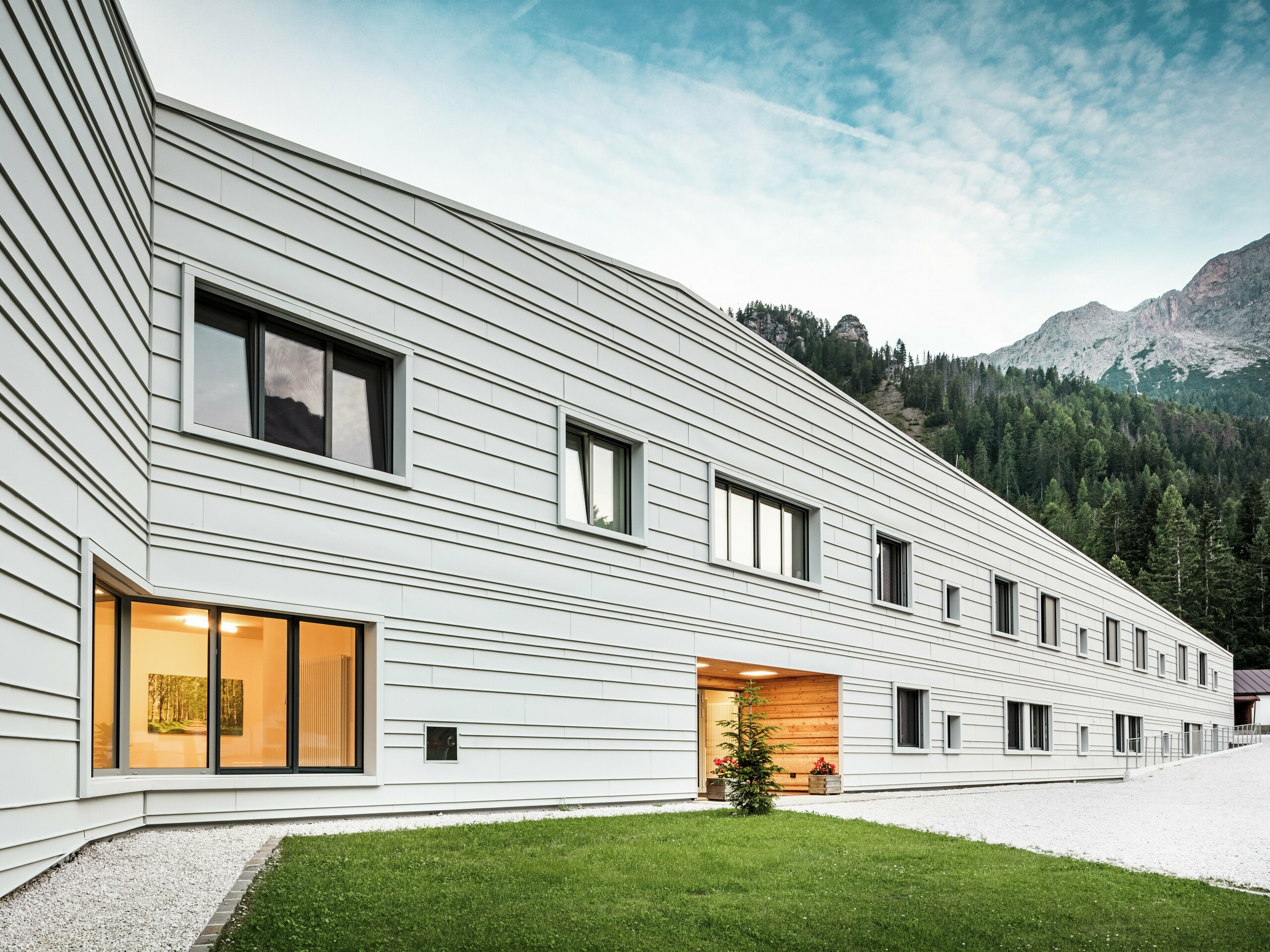 Die moderne Kaserne „Tempesti“ in Südtirol besticht durch ihre klare Fassadengestaltung aus PREFALZ P.10 in der Farbe Prefaweiß. Die horizontal und in unregelmäßigen Abständen verlegten Aluminiumscharen lassen das Bauwerk optisch länger wirken. Die helle Aluminiumfassade reflektiert das Sonnenlicht und sorgt so für ein verbessertes Mikroklima. Die moderne Kaserne ist ein architektonisches Statement inmitten alpiner Natur.