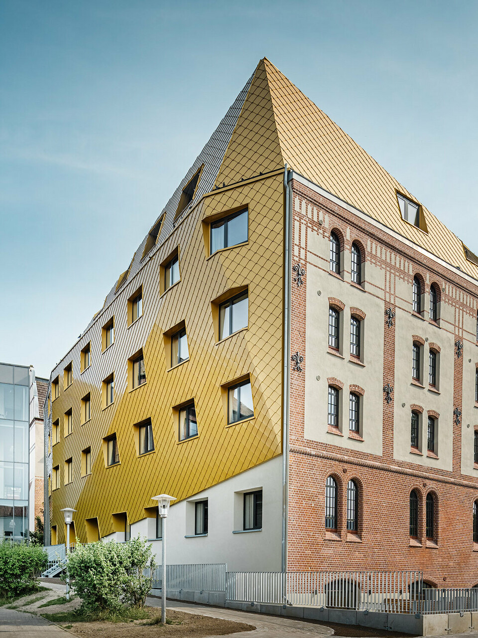 Das Studentenwohnheim aus der Froschperspektive: Die historische Fassade erstreckt sich rechts, die neue PREFA Hülle stülpt sich links bis über das Dachgeschoss.