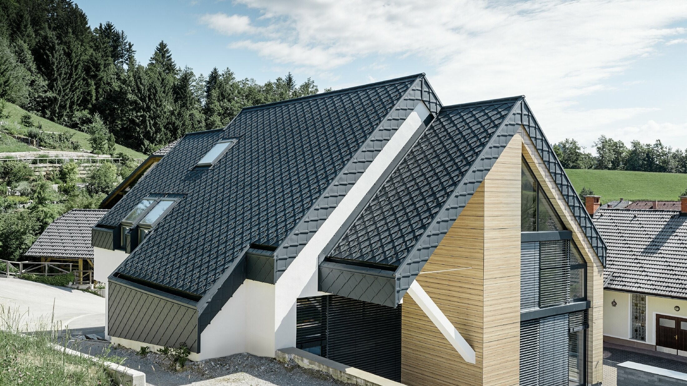 Einfamilienhaus mit Satteldach ohne Dachvorsprung mit einer Fassade in Holzoptik und einem Aluminiumdach in anthrazit